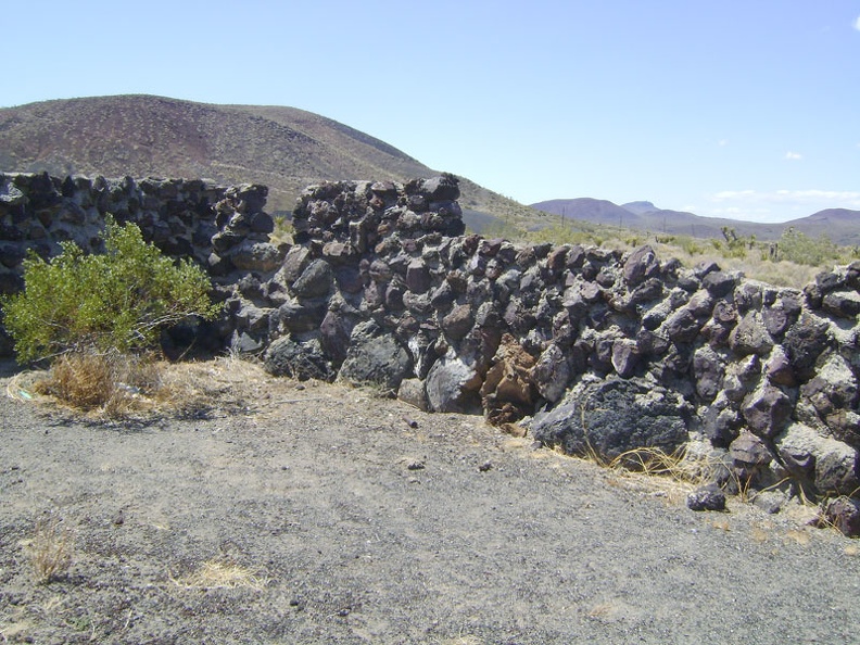 I walk back down the hill from the Aiken Mine equipment to examine a rock wall on the flats