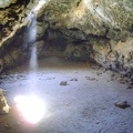 A beam of warm desert light shines down through the ceiling into the main room at the Lava Tube