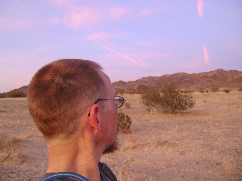 The brilliant pink Mojave Desert sunset is reflecting in the clouds to the east of me