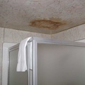 The stained ceiling in the bathroom tells a story of a shower in the room above that leaked