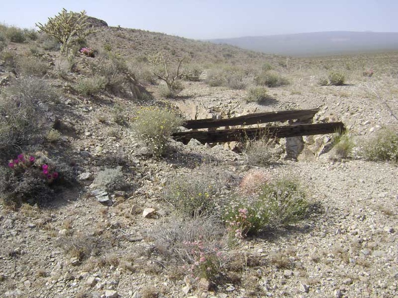 Two large timbers span the opening of a shaft at the second mine site