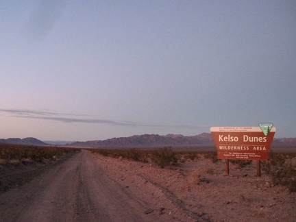 I pass the Kelso Dunes Wilderness sign at dusk, enjoying the views toward the Bristol Mountains, where I hiked yesterday