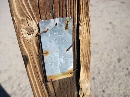 I notice a very weathered old fence post with a metal claim marker as I approach Broadwell Dry Lake