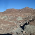 Just beyond the natural arch is Broadwell Mesa and greyish-green minerals coming to the surface everywhere