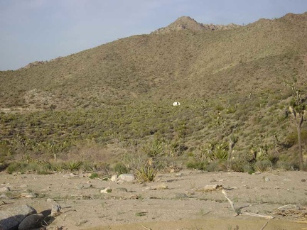 To my right is an old trailer on a hillside that I'm not expecting to see, so I start hiking cross-country toward my tent