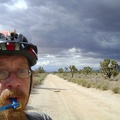 I pop out from under the dark clouds to bright sunshine and a smoother part of Aiken Mine Road, so I'm back on the bike