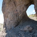 I crouch and walk through this little rock arch in the Castle Peaks area