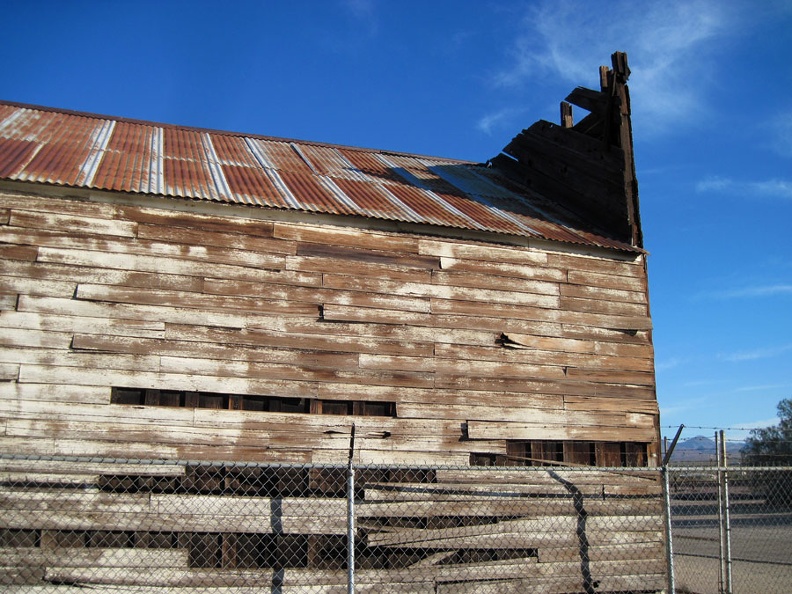 The siding of the old wooden building is peeling away as the structure sags