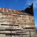 The siding of the old wooden building is peeling away as the structure sags
