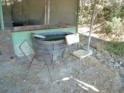 Nice cool water is piped from the spring into this big Rubbermaid tub. Two creaky chairs invite visitors, sort of.