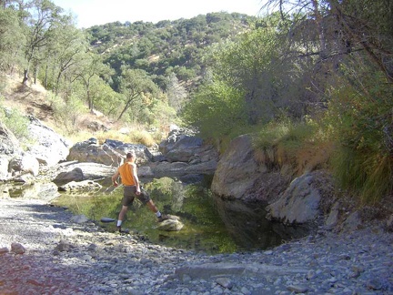 Stepping out onto a rock that rises above water level in the China Hole pool.