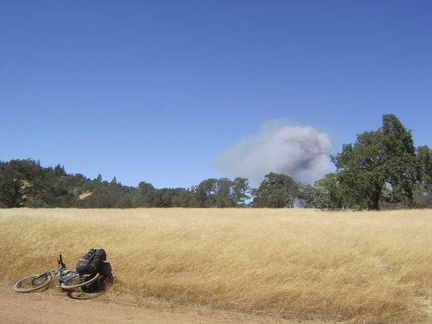 I reach a flat area on Manzanita Point Road and see smoke not far away; looks like a brush fire in Henry Coe State Park.