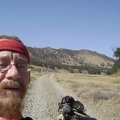 Before I remount the 10-ton bike and turn back, I snap a shot of us with the Rooster Comb in the background.