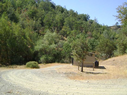 I park the 10-ton bike on the shady side of the Kelly Lake outhouse and go for a short walk toward the lake