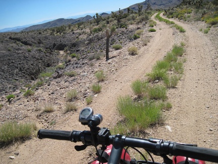 All packed up, I ride down the dirt road away from my Malpais Spring campsite