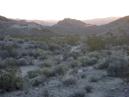 The impending sunset illuminates the distant power lines