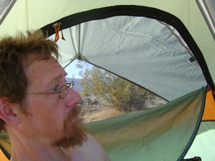 It's a hot morning, probably in the high 70s; I mount the rain cover on the sunny side of the tent to get some shade