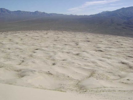 Getting ready to climb down the steep face of Kelso Dunes, with Granite Mountains in the background