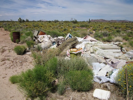 A pile of debris sits in front of the little house on Cedar Canyon Road