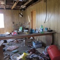 I peer through a broken window at the disarray inside the house