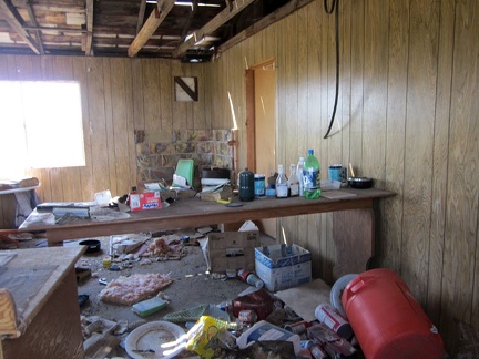 I peer through a broken window at the disarray inside the house