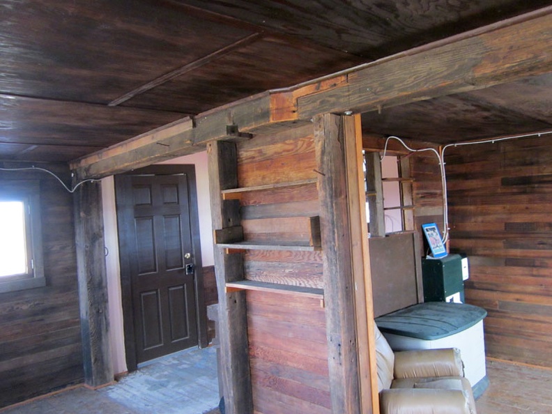 A small kitchen hides behind these built-in shelves; interesting joint in the beam