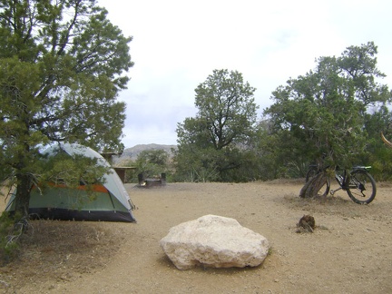 After a half-mile ride down to the kiosk to pay for one more night camping, I return to site 22 and lock the bike to a juniper