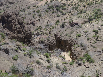I climb up the hill above the slot canyon and look back down into the area above Malpais Spring