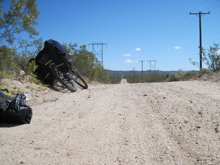 I walk my packed saddlebags back to the powerline road, assemble the 10-ton bike, then ride a short distance to reach pavement