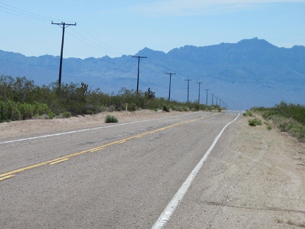 An old-style power line follows Kelbaker Road as it descends past the Kelso Mountains toward Kelso