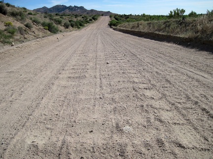 Looking behind me at the heavily washboarded surface of Cedar Canyon Road as it drops into Cedar Wash