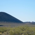 I zoom in across an expanse of yellow creosote-bush blooms to one of the nearby cinder cones