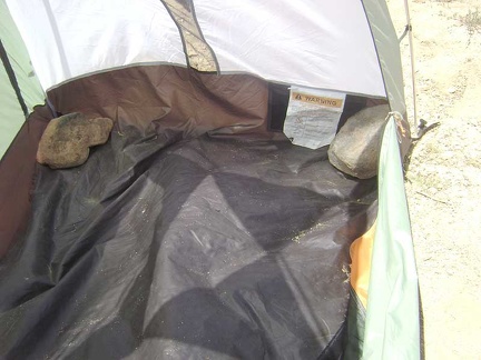  I begin dismantling the tent by removing the large rocks that I placed inside at the corners