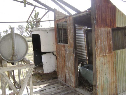 Behind the house at Death Valley Mine is a tank presumably for stove and furnace oil, and an exterior bathtub room