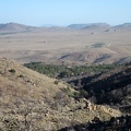 I find myself on a open area of the New York Mountains from which my eyes can follow Black Canyon Road across Round Valley