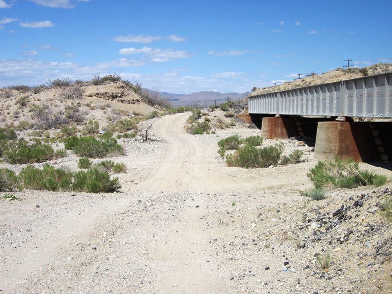 Lonely Nipton-Moore Road dips down to cross numerous drainage washes as it crosses the desert alongside the train tracks