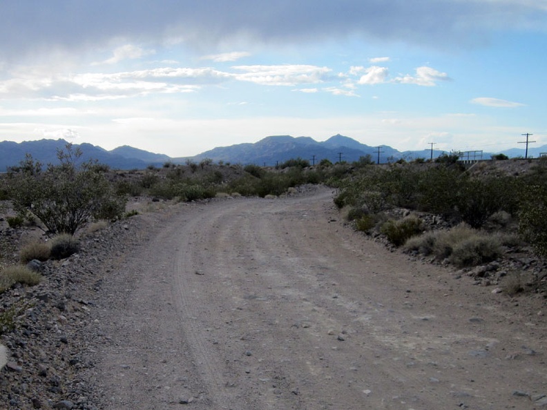 Nipton-Desert Road comes out from under a few dark clouds as I ride toward Primm