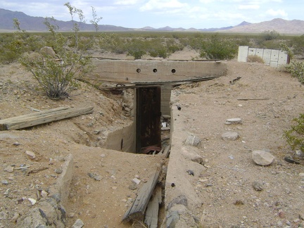 A concrete stairwell and heavy steel door lead into the basement