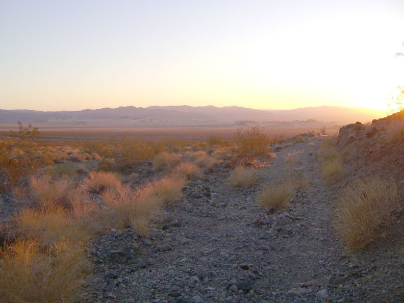 Pinkish light flows over the Devil's Playground at sunset