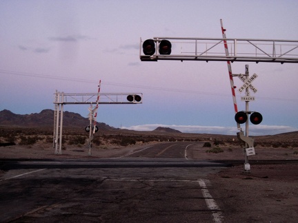 The sun fades away as old Route 66 crosses the train tracks at-grade near Pisgah siding