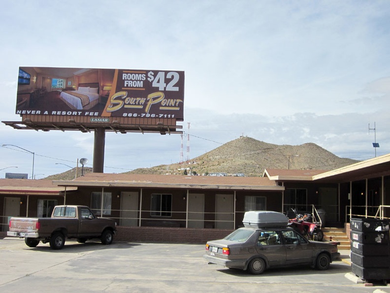 A billboard next to the Searchlight motel advertises a "luxury" motel elsewhere