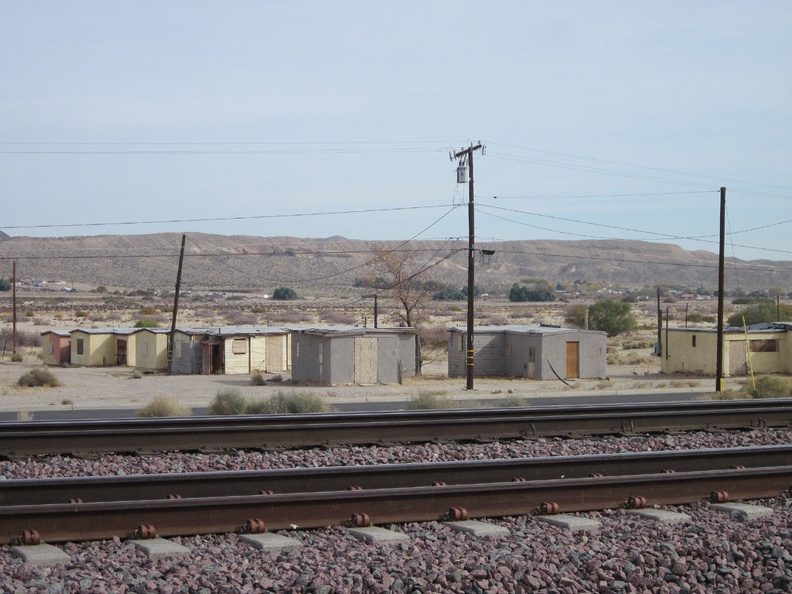 Tomorrow morning, I look across the train tracks at Barstow Station toward old cabins while waiting for my Amtrak bus