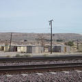 Tomorrow morning, I look across the train tracks at Barstow Station toward old cabins while waiting for my Amtrak bus