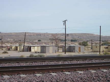 Tomorrow morning, I look across the train tracks at Barstow Station toward old cabins while waiting for my Amtrak bus