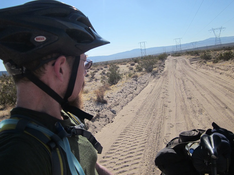 I pause on the way up the gentle hill leading into the Cady Mountains to look back on the sandy road