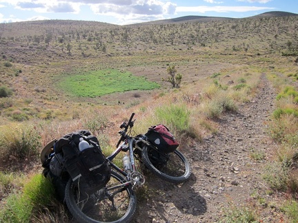 Between the rolling hills, Castle Peaks Road rises up a short steep hill onto a man-made berm overlooking a dry reservoir