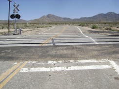 The signs behind me warned that the road would turn sharply to the left after crossing the tracks