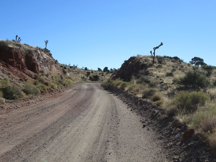 Ivanpah Road passes through a blasted slot through the rocky landscape