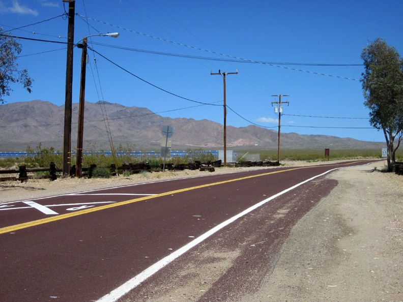 I glance at Nipton's little solar-power plant as I begin the ride up the hill toward Crescent Pass, Nevada