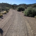 My nice firm road surface transforms into shallow "kitty litter" as the road passes through a wash area